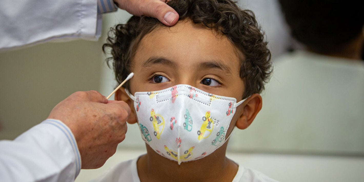 Un médico mide la circunferencia de la cabeza de un niño paciente