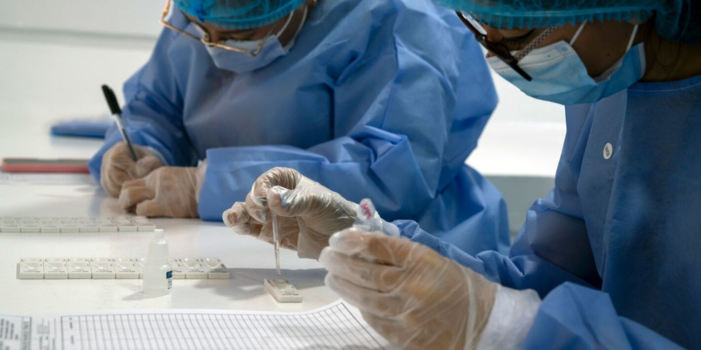 Trabajadores de la salud con kits de prueba en un laboratorio.