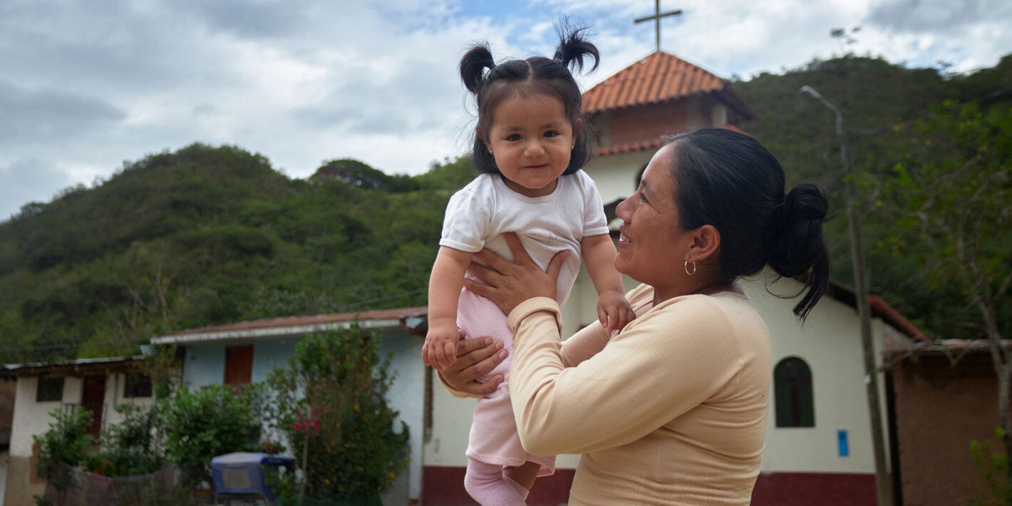 Madre carga a su hija bebé y la eleva