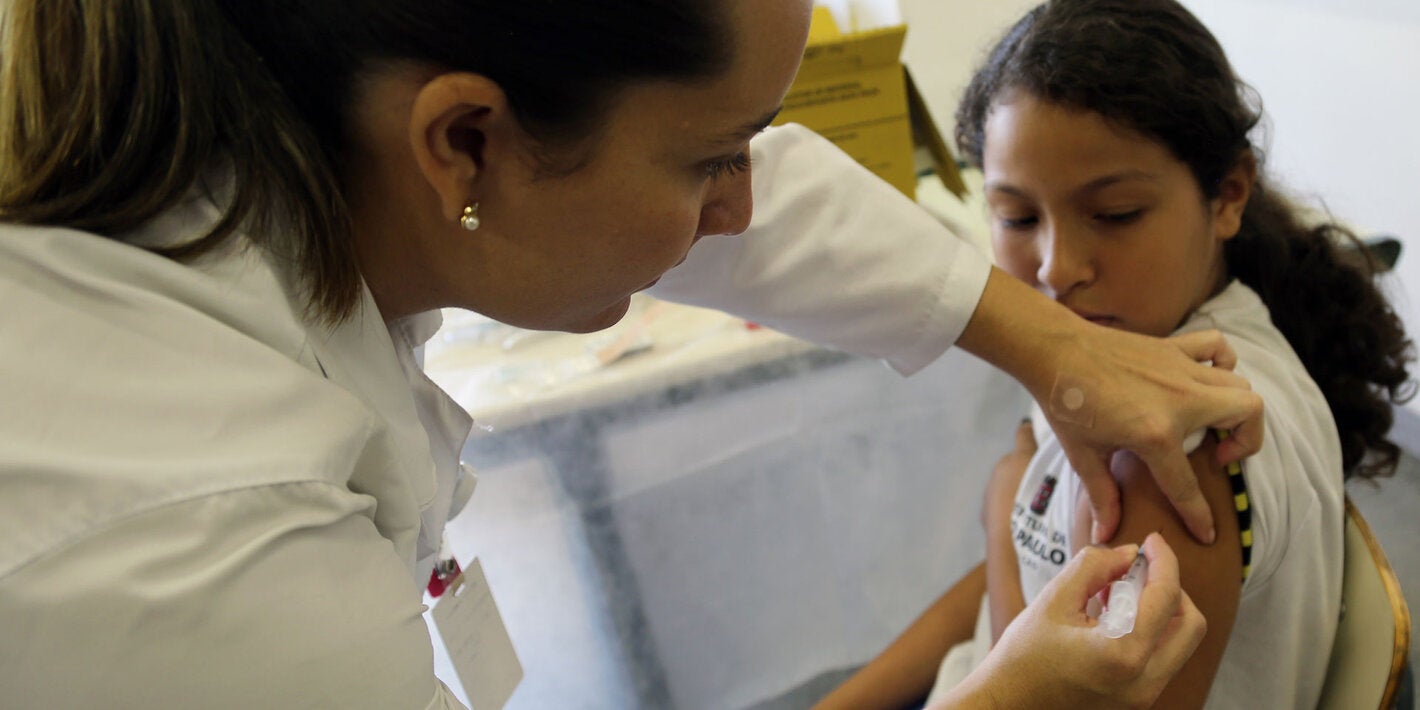 Healthcare professional vaccinates a teen girl in the arm against HPV