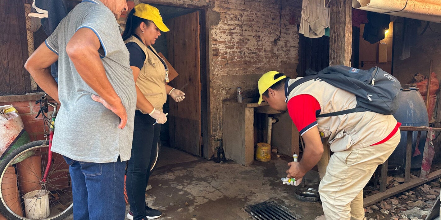 Personal del Ministerio de Salud de Paraguay realiza una inspección de la casa para eliminar posibles criaderos de mosquitos