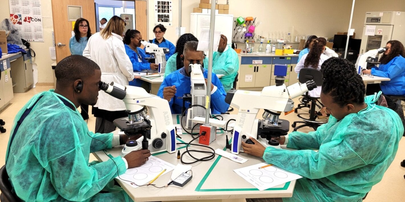 Especialistas que participaron en el taller, sentados haciendo observaciones en el microscopios