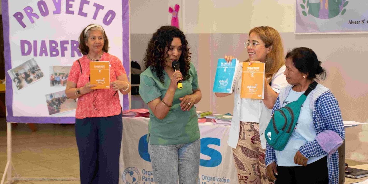 Foto con participantes del programa y del equipo de salud mostrando los distintos pasaportes con sus ejercicios indicados. Hya un cartel hecho a mano que dice proyecto Diabfrail