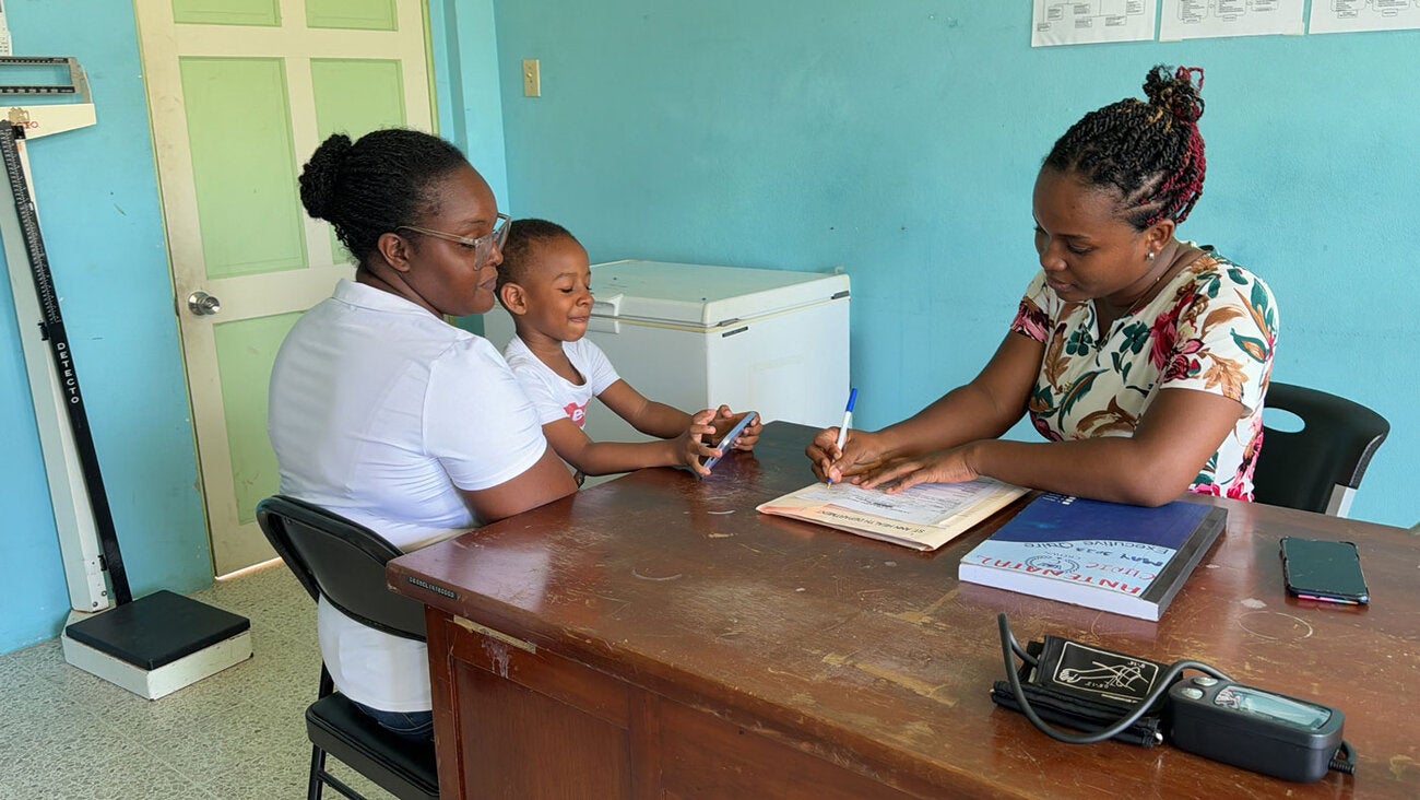 Mother and child at clinic interacting with a female doctor