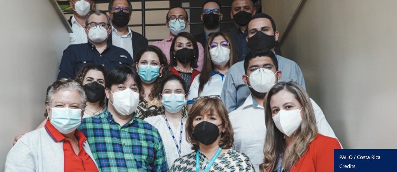 Group of people wearing facemasks, posing for the camera - event participants