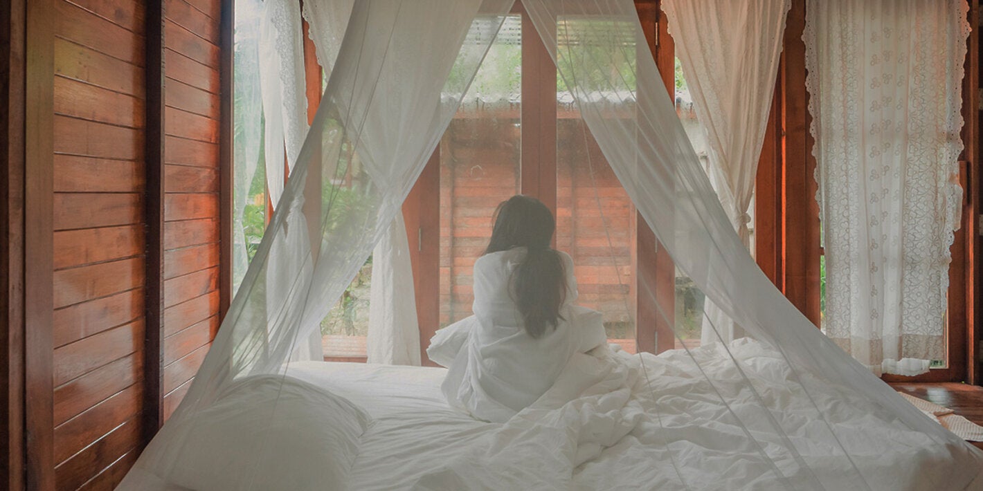 woman under mosquito net