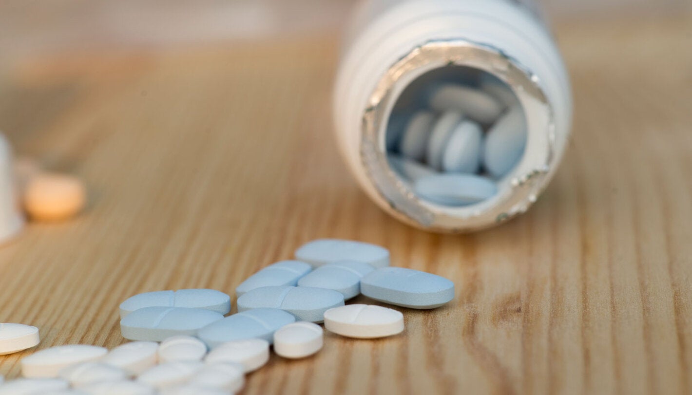 Pills spilling out of a jar of medicine