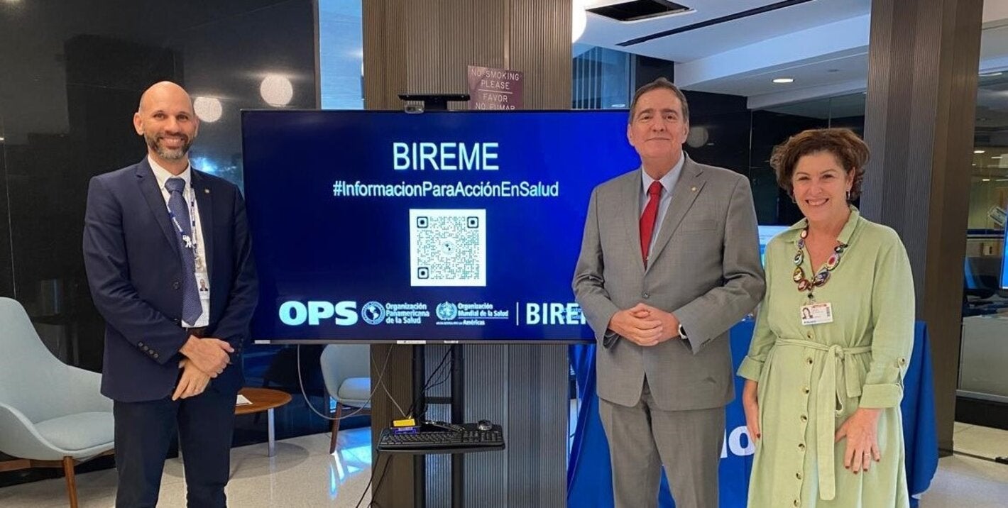 Fotografía muestra al Dr. Barbosa Director de la OPS con João Paulo Souza, Director de BIREME, y Veronica Abdala, Gerente de BIREME. Están parados frente al stand de BIREME en CD61.