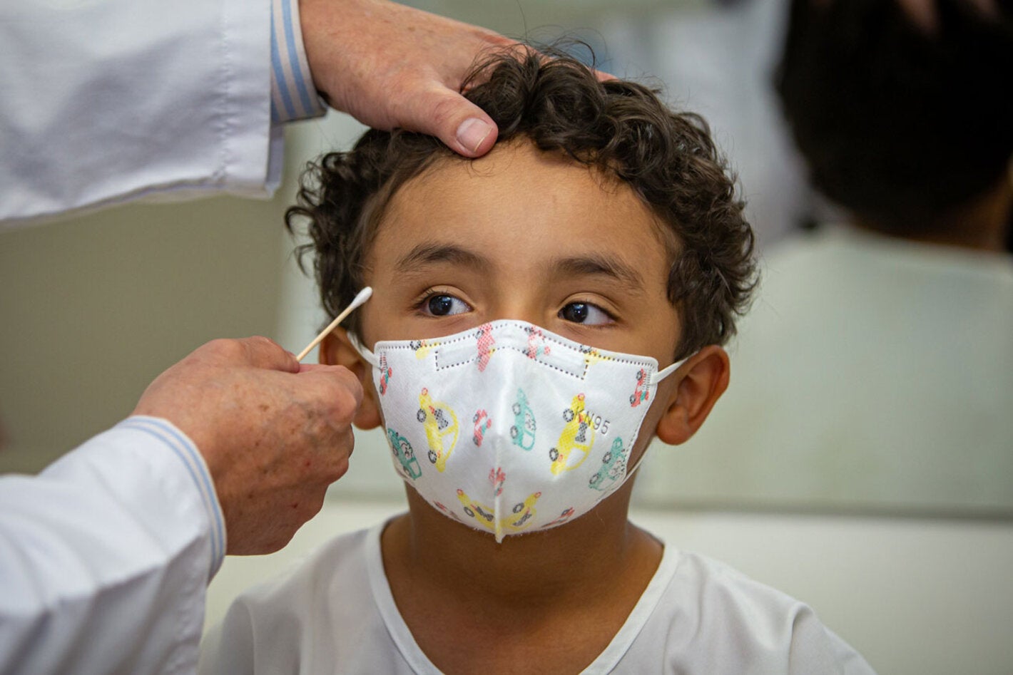 Un médico mide la circunferencia de la cabeza de un niño paciente