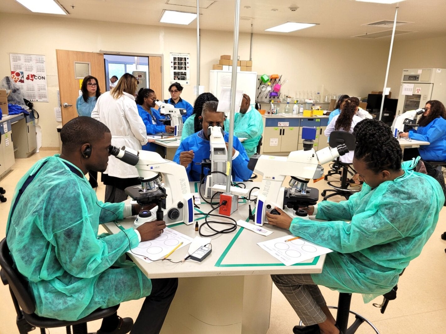 Especialistas que participaron en el taller, sentados haciendo observaciones en el microscopios