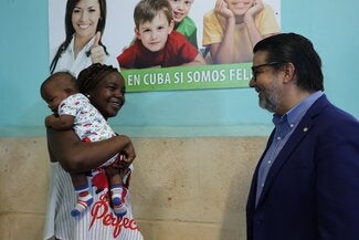 Madre conversa con Representante de OPS/OMS en Policlínico Lawton durante vacunación antineumocócica en Cuba