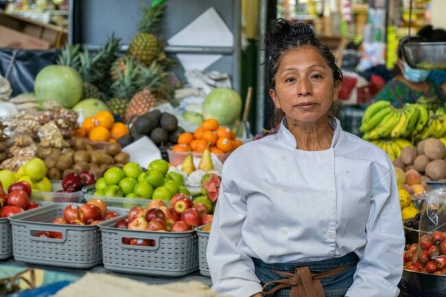 ""mujer en mercado con frutas 