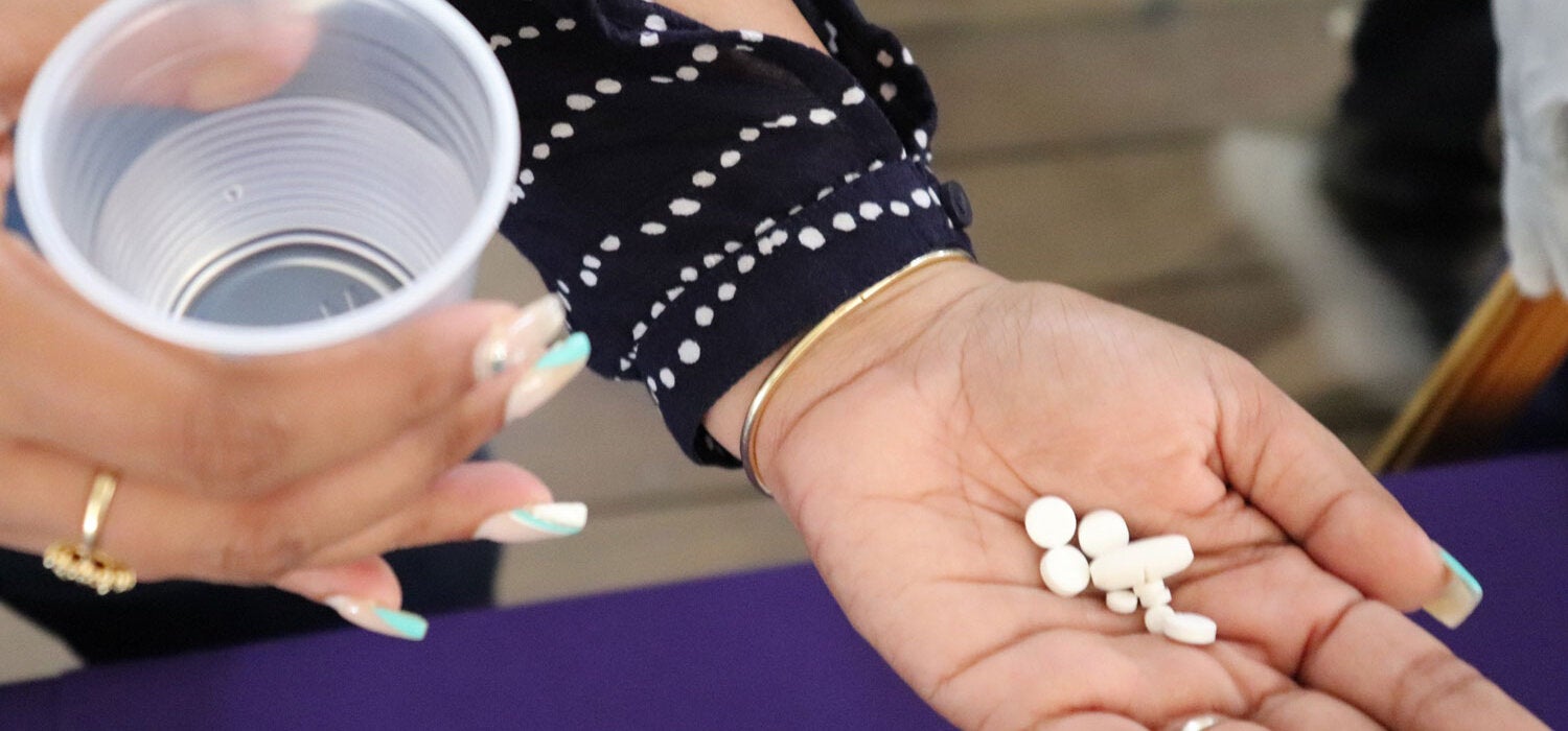 Una mujer tiene las pastillas en su mano para tratar la filariasis linfática