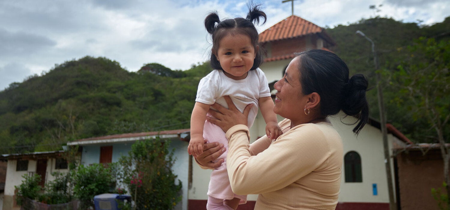 Madre carga a su hija bebé y la eleva