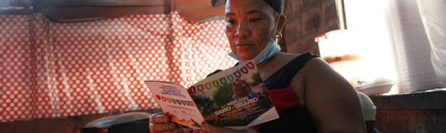 Mujer lee folleto mercado saludable en frontera