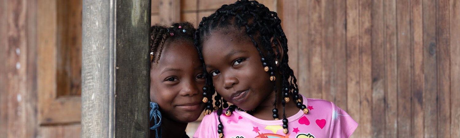 Niñas sonrientes en un marco de ventana