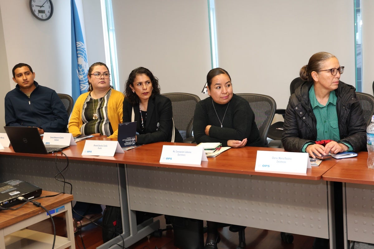 Foto algunos participantes del taller, sentados en la sala de reuniones, prestando atención a los ponentes